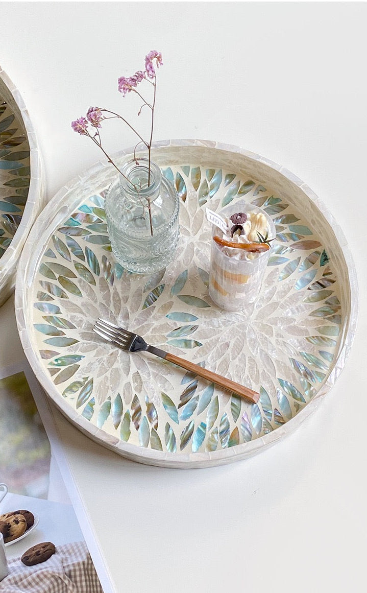 Decorative round tray with floral pattern on a white surface