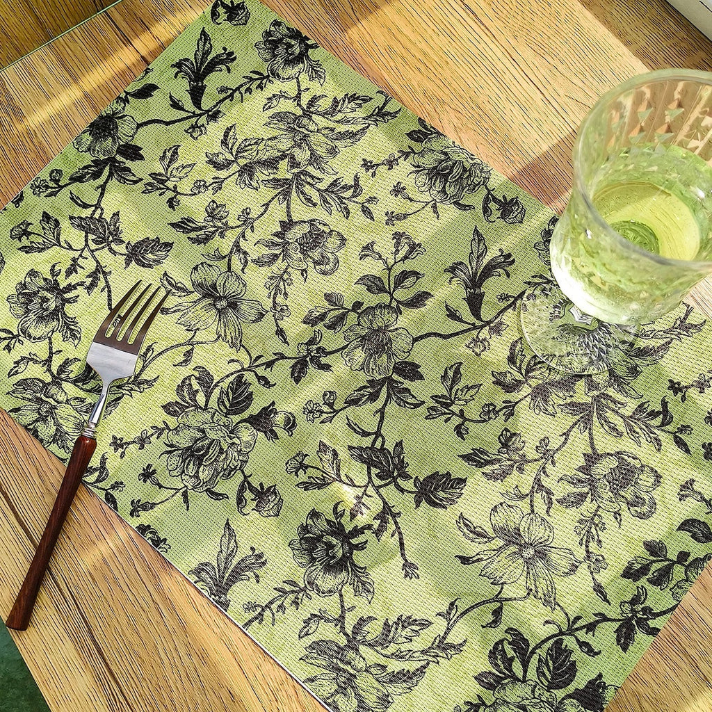 Floral patterned placemat with a glass and fork on a wooden table