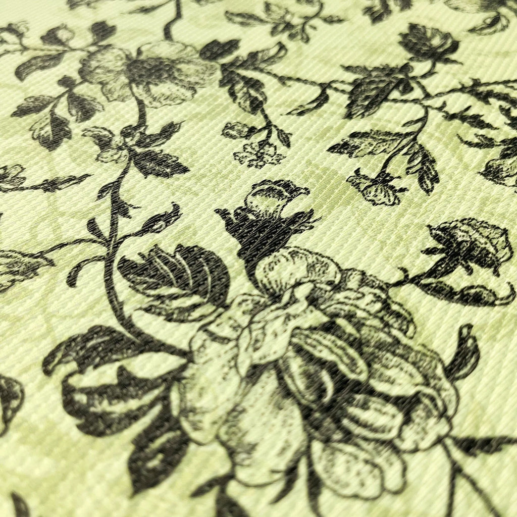 Close-up of floral patterned fabric with black flowers on a light green background