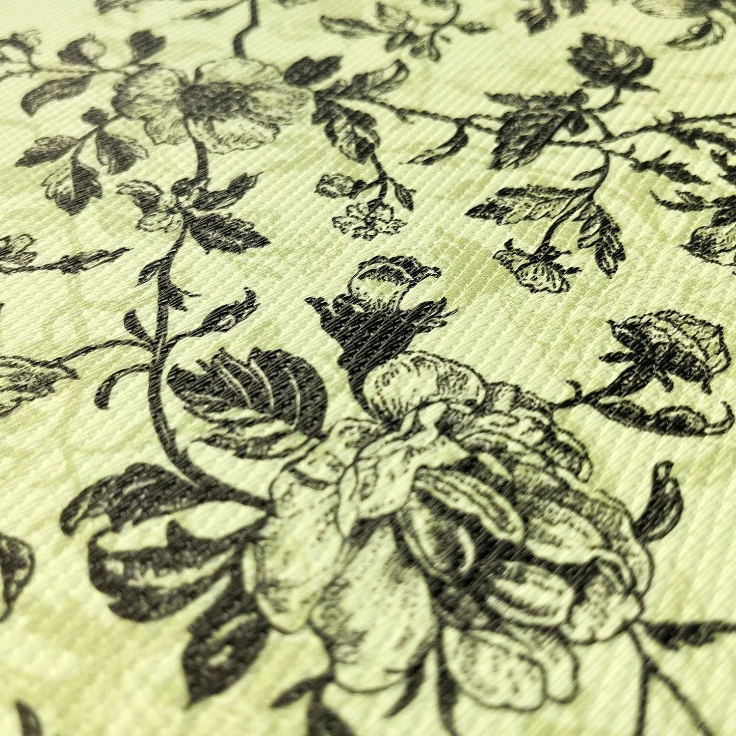 Close-up of floral patterned fabric with black flowers on a light green background